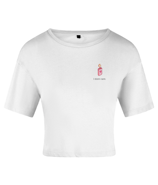 A white crop top with a crew neckline and short sleeves, featuring a sketch-style lighter design in pink and the text 'I don't care' on the chest. On a white backdrop.