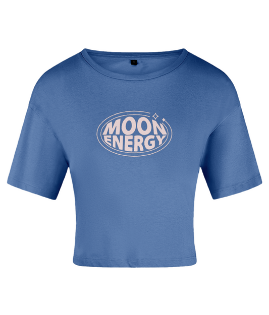 A blue crop top with 'MOON ENERGY' text logo in pink, surrounded by pink lines and stars accent. On a white backdrop.