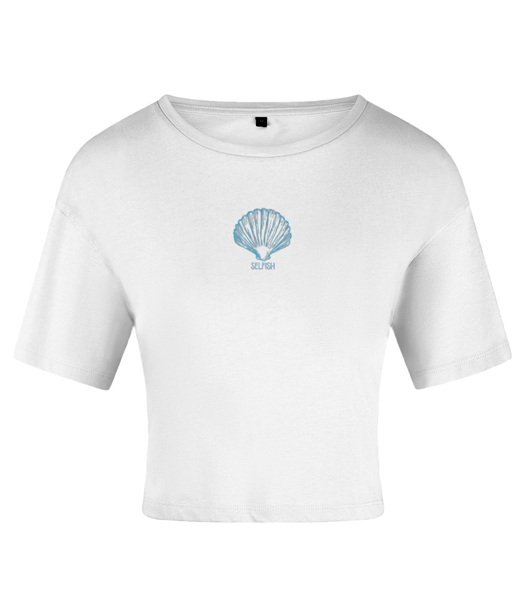 A white crop top with a blue seashell graphic and the word 'Selfish' printed below it, in a relaxed-fit style with short sleeves and a crew neckline. On a white backdrop.